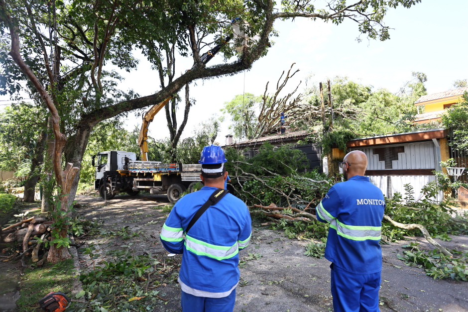 Trabalhadores da equipe de manutenção da cidade removem galhos de árvore que caíram por conta das fortes chuvas