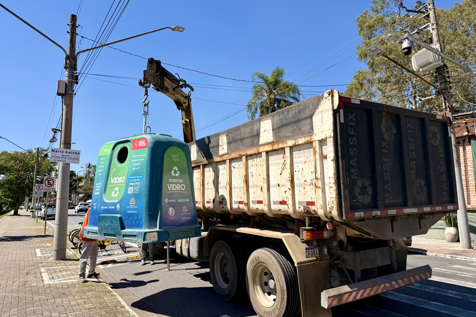 Caminhão da Massfix recolhe o volume de vidro dentro do contêiner verde na Avenida Anchieta