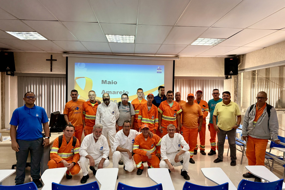 Motoristas da coleta, vestidos de uniformes laranja, se reuniram para realizar treinamento de direção defensiva