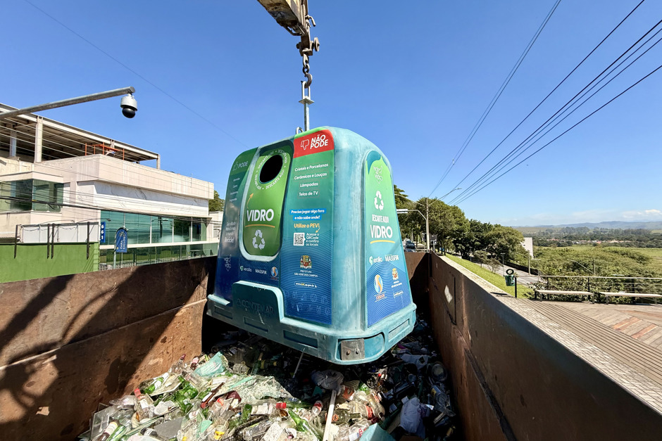 Ecoponto é enganchado ao topo do caminhão da coleta de vidro para despejar o material na caçamba